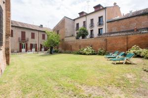 un gruppo di sedie seduti nel cortile di un edificio di PALAZZO SABBIONI APPARTAMENTO LUSSO due CAMERE SOGGIORNO CUCINA a Ferrara