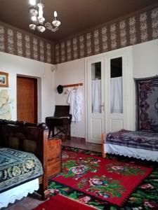 um quarto com duas camas e uma porta com um piano em Apartmani Dragulj em Kula