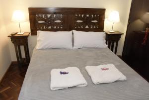 a bed with two towels on it with two lamps at Departamento Balcarce Jujuy 4B in San Salvador de Jujuy