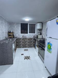 a kitchen with a white floor and a refrigerator at Beit Al Hasan بيت الحسن in Um Qeis