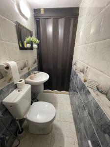biała łazienka z toaletą i umywalką w obiekcie Beit Al Hasan بيت الحسن w mieście Um Qeis