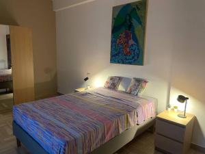 1 dormitorio con 1 cama y una pintura en la pared en A Casa di Anna: appartamento in centro storico, en San Pietro