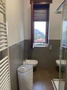 uma casa de banho com um lavatório, um WC e uma janela. em A Casa di Anna: appartamento in centro storico em San Pietro