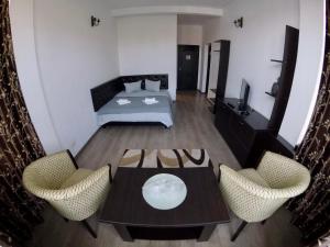 um quarto com uma cama, uma mesa e cadeiras em Cochet Accommodation em Piatra Neamţ