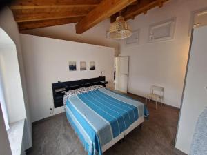 a bedroom with a bed with a blue comforter at ALL NEW and AIR-CONDITIONED La GRAZIOSA apartment in Genoa