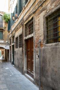 an old brick building with a brown door on a street at Cianis Home San Marco - Apartment in Venice
