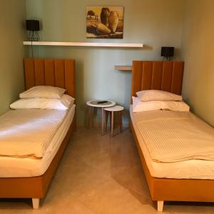 two twin beds in a room with a table at Noclegi VIVA in Mszczonów