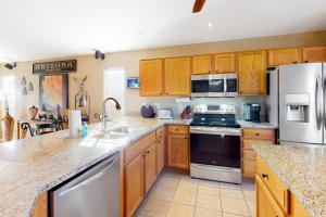 a kitchen with wooden cabinets and stainless steel appliances at Gold Canyon Getaway in Gold Canyon +20 photos