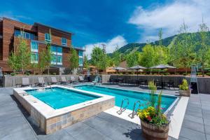 a pool at a resort with tables and chairs at SpringHill Suites by Marriott Jackson Hole in Jackson