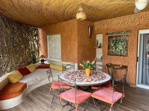 a bedroom with a bed and a table and chairs at Villa Les CoCotiers in Saly Portudal