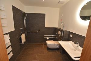 La salle de bains est pourvue de toilettes, d'un lavabo et d'une douche. dans l'établissement Gasthof Lebzelter, à Straßwalchen