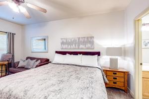 a bedroom with a bed and a table with a lamp at Wildwood Adventures - Unit B in Branson