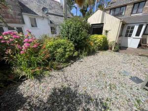 a yard in front of a house with flowers at The Old Barn in St Ives