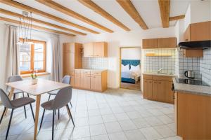 a kitchen with a table and chairs and a bedroom at Hotel Greif in Malles Venosta