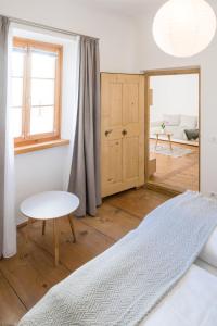 Schlafzimmer mit einem Bett, einem Tisch und einem Fenster in der Unterkunft Hotel Greif in Mals im Vinschgau