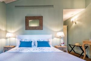 ein Schlafzimmer mit einem großen weißen Bett mit blauen Kissen in der Unterkunft Isola Bella Apartments Via Stretta in Stresa