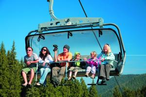 a group of people sitting on a ski lift at Chata Ski Chopok in Belá