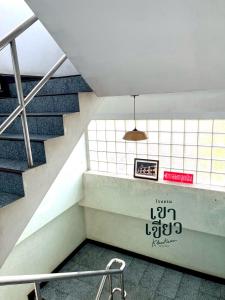 un escalier dans un bâtiment avec un panneau sur le mur dans l'établissement KHAO KIEOW Hotel โรงแรมเขาเขียว, 