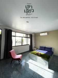 1 dormitorio con 1 cama y 1 silla rosa en KHAO KIEOW Hotel โรงแรมเขาเขียว, 