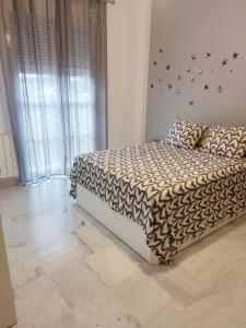 1 dormitorio con 1 cama con edredón blanco y negro en Acogedora casa adosada, en Alhendín