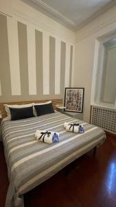 1 dormitorio con 1 cama grande y 2 almohadas en Popolo Dream Suites - Luxury Rooms, en Roma