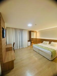 um quarto de hotel com uma cama grande e uma secretária em Suíte Condomínio Vista Azul - Pedra Azul em Domingos Martins