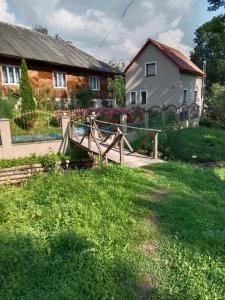 une maison avec une clôture en bois et une cour dans l'établissement Котедж, à Podobovets