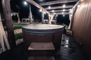 a large wooden tub with a bench in front of it at VILLAGE RESORT Sauna & Jacuzzi & Netflix in Tworkowa