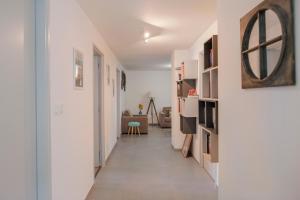 un pasillo que conduce a una sala de estar con paredes blancas en Le Solaret, en Sète