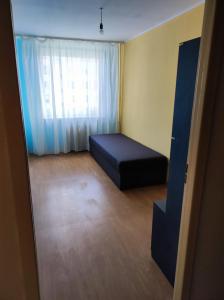 Habitación pequeña con cama y ventana en Apartament na Wyszyńskiego - Noclegi, mieszkanie dla firm i pracowników, en Myszków