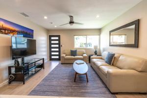 a living room with a couch and a flat screen tv at Coronado Bayside Charmer in San Diego