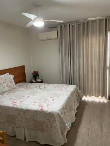 a bedroom with a bed with a white blanket and a window at Vilage Bed & Breakfast in Volta Redonda