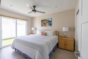 a bedroom with a large bed with a ceiling fan at Coronado Bayside Charmer in San Diego