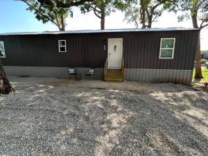 una pequeña casa marrón con una puerta blanca y sillas en Parkside B&B en Farmington