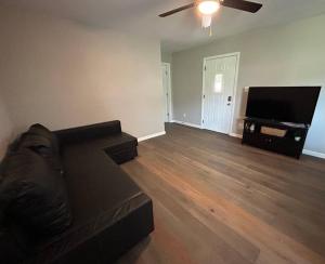 a living room with a couch and a flat screen tv at Parkside B&B in Farmington