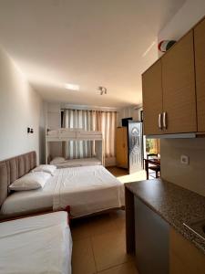 um quarto de hotel com duas camas e uma cozinha em Hotel Belle Vue em Ksamil