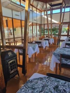 a restaurant with tables and a wood stove at Hotel ACA Eldorado in Eldorado