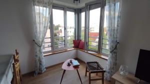 La Verrière في ديجون: غرفة مع نوافذ كبيرة مع طاولة وكراسي وردية