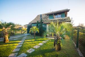 una casa con palmeras en el patio en Casa na Barra de Ibiraquera en Barra de Ibiraquera