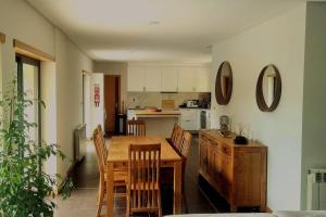 a kitchen with a wooden table and chairs at Casa Picone - Gerês in Ventosa