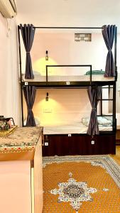 Pokój z 2 łóżkami piętrowymi i stołem w obiekcie The BackpackStack w mieście Ujjain