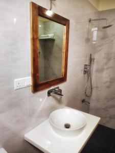 een badkamer met een witte wastafel en een spiegel bij Great Residence in Avissawella