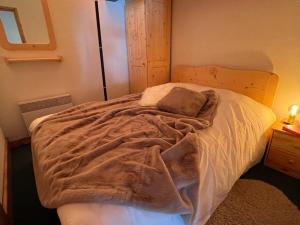 um quarto com uma cama grande e um cobertor em Appartement Méribel, 4 pièces, 6 personnes - FR-1-688-49 em Méribel