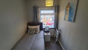 ベルファストにあるRavenhill Townhouse Belfastのベッドと窓のある小さな寝室