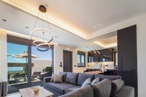 sala de estar con sofá y mesa en Four Horizons Luxury Villas, en Kournás
