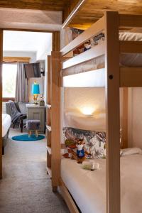 クールシュヴェルにあるHôtel Courcheneigeのベッドルーム1室(二段ベッド2組付)、リビングルームが備わります。