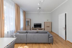 un salon avec un lit et une télévision dans l'établissement Prestigious city center apartment with free parking by Polo Apartments, à Kaunas