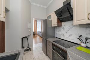 - une cuisine avec des murs blancs et des comptoirs en marbre dans l'établissement Prestigious city center apartment with free parking by Polo Apartments, à Kaunas