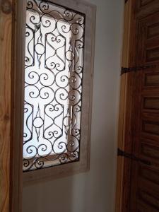 eine Tür mit einem Fenster mit einem Metallgitter in der Unterkunft Cornise in El Rompido