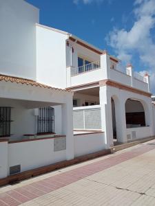 ein weißes Haus mit einem Balkon an der Seite in der Unterkunft Cornise in El Rompido